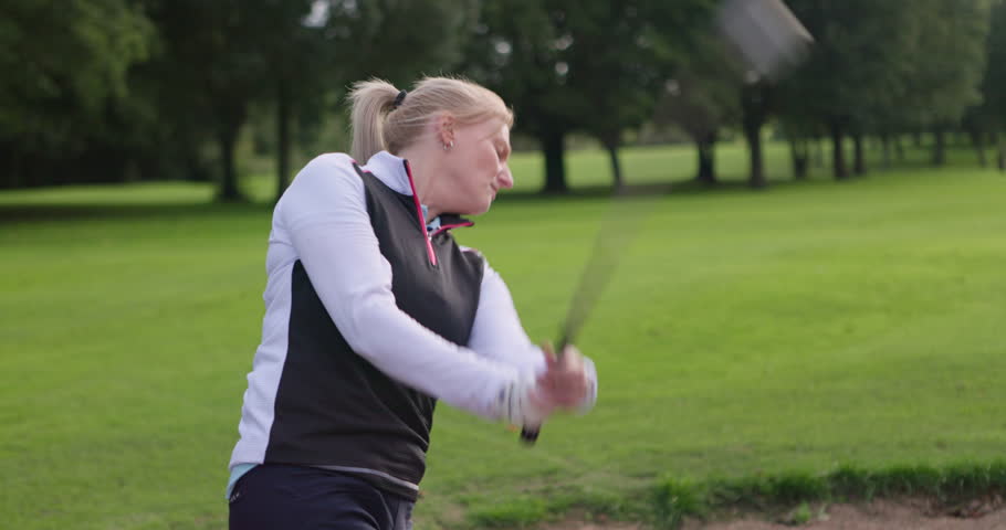 Training, golf course and a woman golfer swinging a club outdoor for competition during a game. Summer, sports and recreation with a person golfing on a green for a leisure hobby or practice