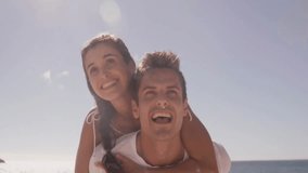 Man giving piggyback ride and woman pointing upward on beach with floating social media emojis. Joy, friendship, leisure, lifestyle, vibrant, outdoor, connection - Powered by Shutterstock - Get 15% off with code: PIKWIZARD15
