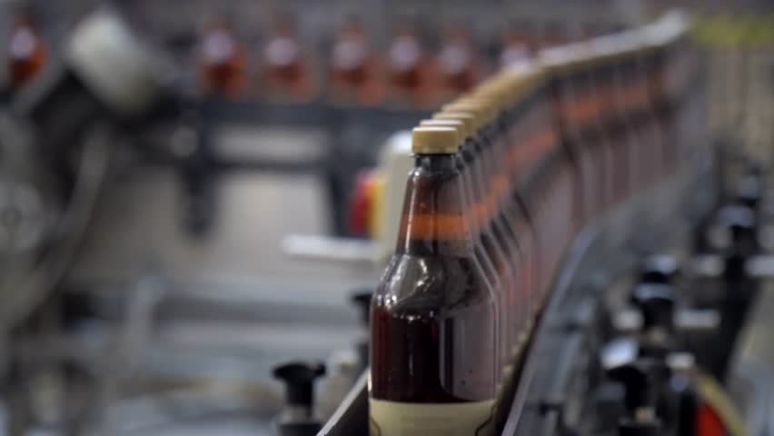Production line, conveyor, aluminum cans with finished beer on a conveyor belt. Brewery inside. Modern production technology