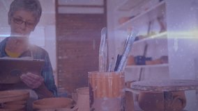 woman wearing glasses working at pottery bench using tablet, showing floating social media icons. Craft, innovation, craftswoman, creativity, vintage, artisan, technology - Powered by Shutterstock - Get 15% off with code: PIKWIZARD15