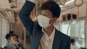 Young businessman in a face mask holds onto a handrail while traveling on a subway, symbolizing health safety, commuting, and urban lifestyle. - Powered by Shutterstock - Get 15% off with code: PIKWIZARD15