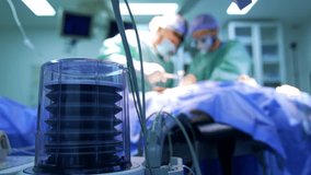 Lung ventilator pump working in surgery room. Close up. Surgeon uses a mallet at operation at backdrop in blur. - Powered by Shutterstock - Get 15% off with code: PIKWIZARD15