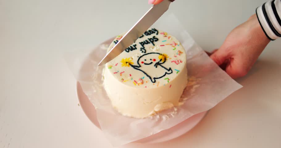 Girl carefully cuts round cake in half and prepares to eat festive sweets. Teenager uses special sharp tool and shapes pieces of cake setting table for party