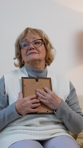 Sad elderly woman with old photo