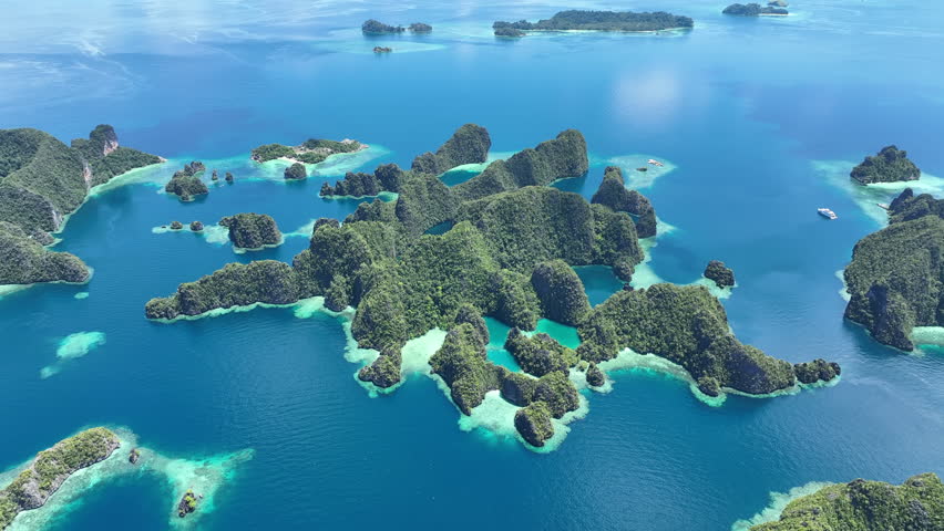 A set of beautiful rock islands rise from the ocean in Misool, Raja Ampat, Indonesia. This area is known as the heart of marine biodiversity and is a popular destination for diving and snorkeling.