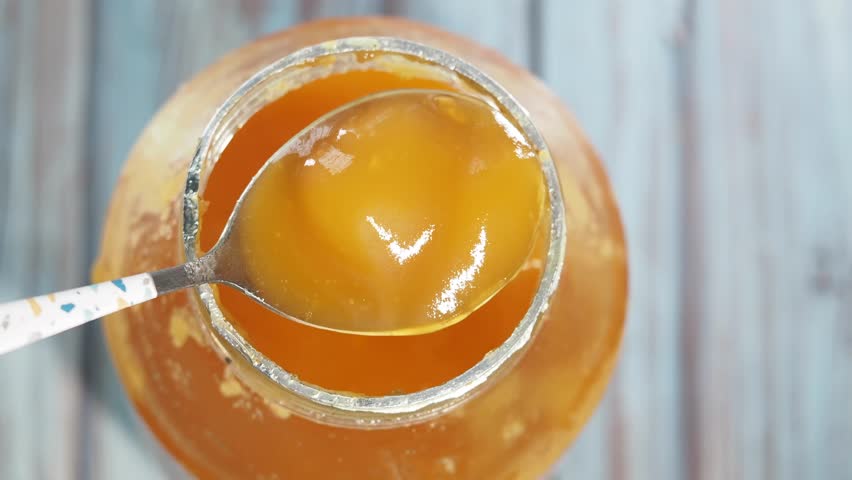 Ghee in a glass jar with a spoon