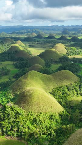 Aerial shot of the interesting rock formations called the Chocolate Hills on Bohol Island in the Philippines. Vertical Video.