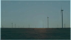 Wind turbines spinning across open field, HUD overlay projecting red globe grid and data columns. Renewable, technology, futuristic, innovation, sustainability, digital, eco-friendly - Powered by Shutterstock - Get 15% off with code: PIKWIZARD15