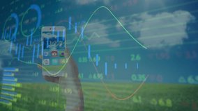 Hand holding smartphone showing weather widget overlaying finance charts with 3D cubes on field. Technology, outdoor, data visualization, digital, landscape, analytics, innovation - Powered by Shutterstock - Get 15% off with code: PIKWIZARD15