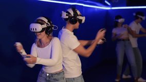 Young couple in VR glasses playing video game against another couple. Friends are enthusiastically playing a game in a virtual reality headset and using joysticks - Powered by Shutterstock - Get 15% off with code: PIKWIZARD15