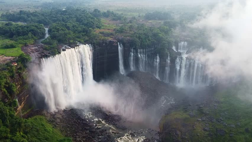 aerial shot showcases kalambo falls with mist and lush greenery surrounding the waterfall area beautifully Angola