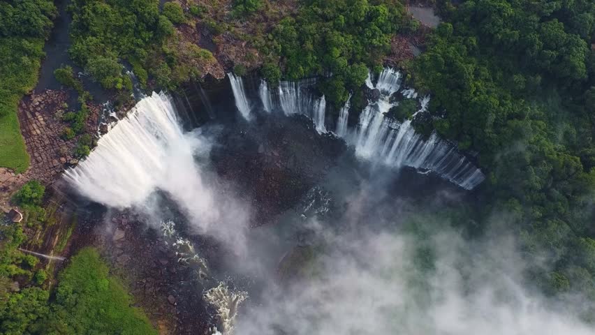 a stunning aerial shot of a waterfall surrounded by dense vegetation, creating a breathtaking landscape Angola