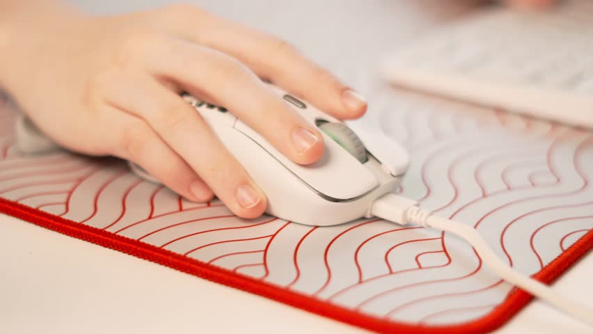 Close-up of fingers working on keyboard and gaming mouse at cozy workstation. Modern workspace setup, gamer place, digital productivity, remote work essentials, freelance and gaming lifestyle.