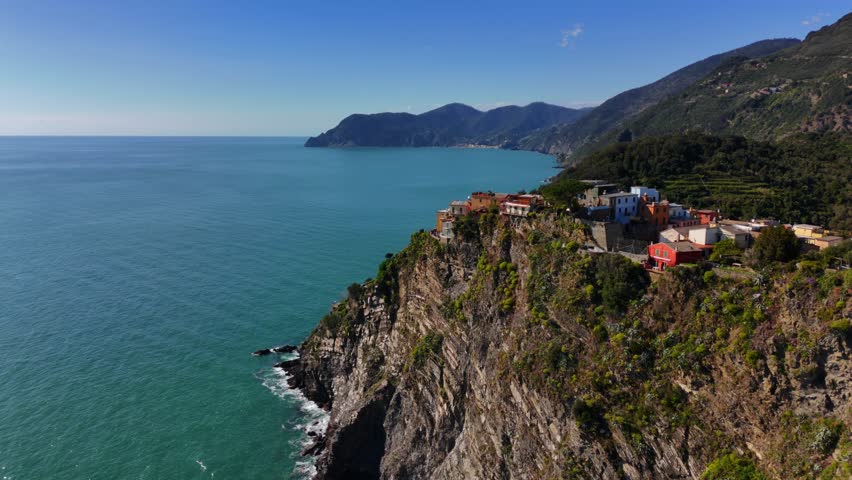 Houses perched on cliffside in Corniglia, Cinque Terre, Italy, with sea and mountains