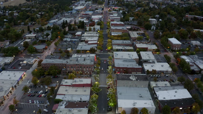 Aerial Tilt Up Scenic Shot Of Decorated Trees In Town By Hills Against Cloudy Sky At Dusk - Moscow, Idaho