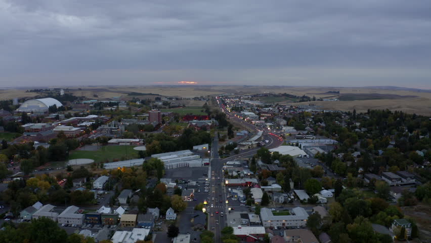 Aerial Panning Scenic View Of Residential Houses In Town By Hills Under Cloudy Sky - Moscow, Idaho