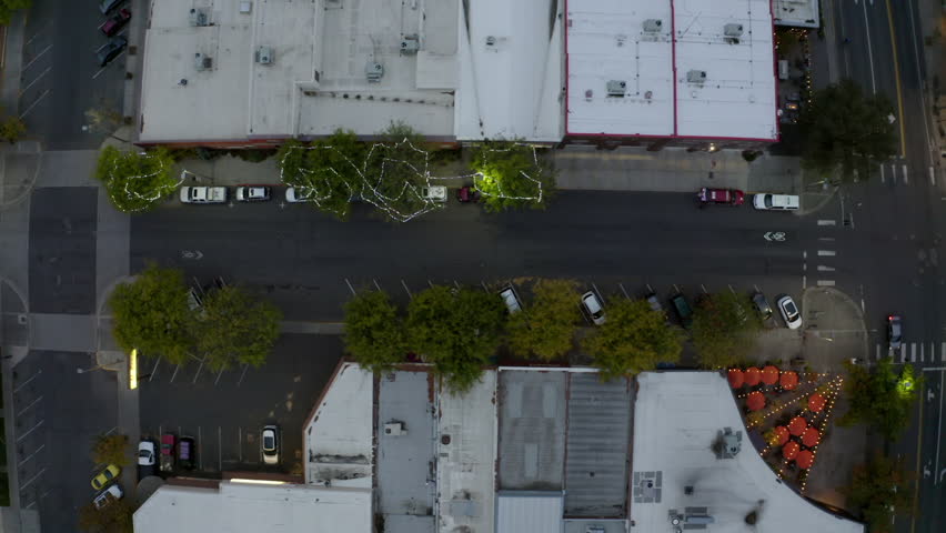Aerial Top Panning Shot Of String Lights On Trees Amidst Buildings In Town At Dusk - Moscow, Idaho