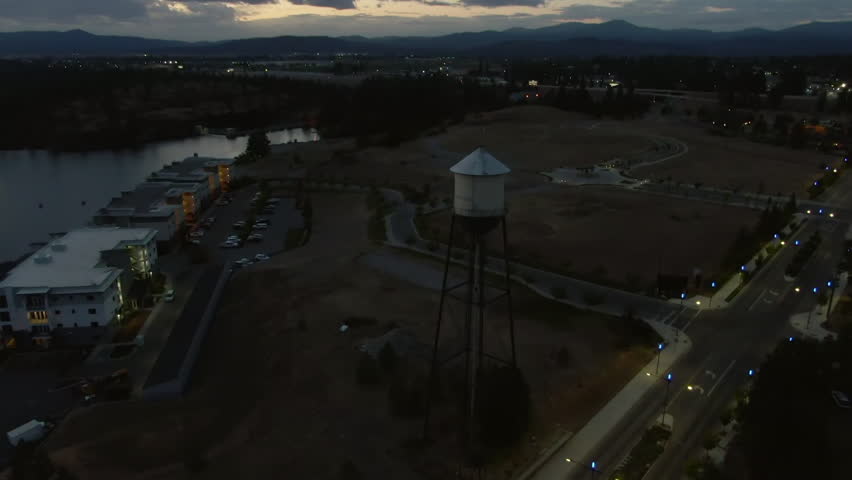 Aerial Tilt Down Scenic View Of Water Tower In Town By Lake At Sunset - Coeur d`Alene, Idaho