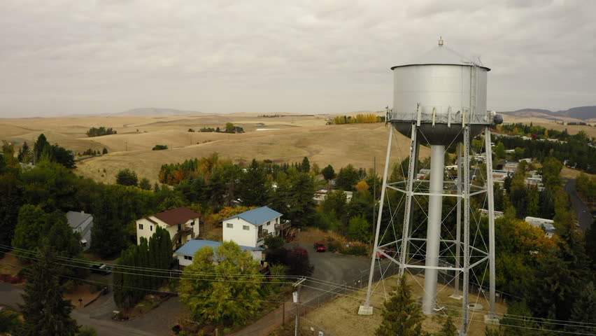 Aerial Forward Scenic Shot Of Water Tower In Residential Town On Hills Under Cloudy Sky - Coeur d`Alene, Idaho