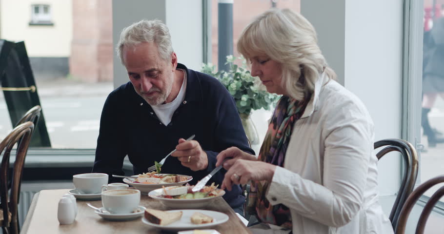 Breakfast, food and senior couple eating together for bonding, quality time and conversation. Restaurant, marriage and mature man and woman in cafe to relax, chat and morning date in coffee shop