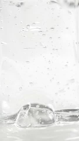 Vertical cosmetics serum gel background, hydrating cream texture, transparent facial mask, skin care and treatment. 