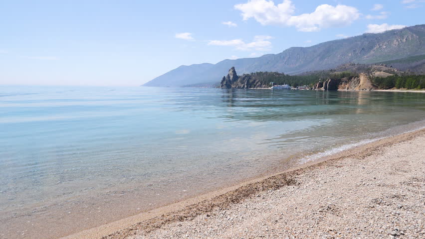 Sandy bay on a summer day. Beautiful view of Cape Kolokolny, sandy beach, clear water of Lake Baikal.