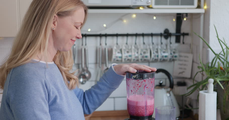 Woman, smoothie and blender in kitchen with detox, fruits and nutrition drink at home. Breakfast, weight loss and female person smile with cooking and nutritionist food in the morning in a house