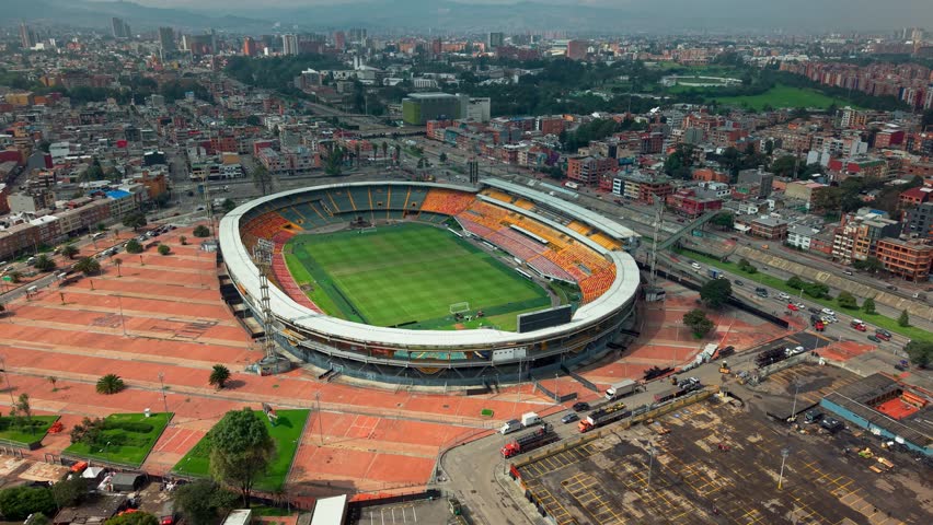 Drone captures a full view of El Campín stadium in Bogotá’s Teusaquillo district, surrounded by dense city blocks and framed by the Andes, showing Colombia’s capital in high-altitude urban sprawl