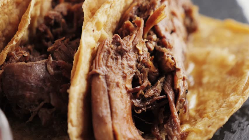 Mexican cuisine concept. Delicious tacos of pulled pork on corn pie close-up. High quality 4k footage