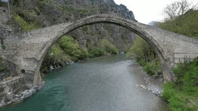 The great arched stone bridge of Plaka on Arachthos river, Tzoumerka, Greece - Powered by Shutterstock - Get 15% off with code: PIKWIZARD15