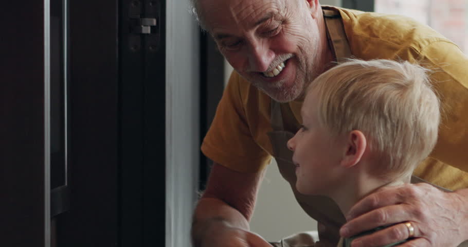 Baking, food in the oven with a grandfather and grandchild in the kitchen of a home together for cooking. Learning, family or children with a senior man and his grandson preparing a snack in a house