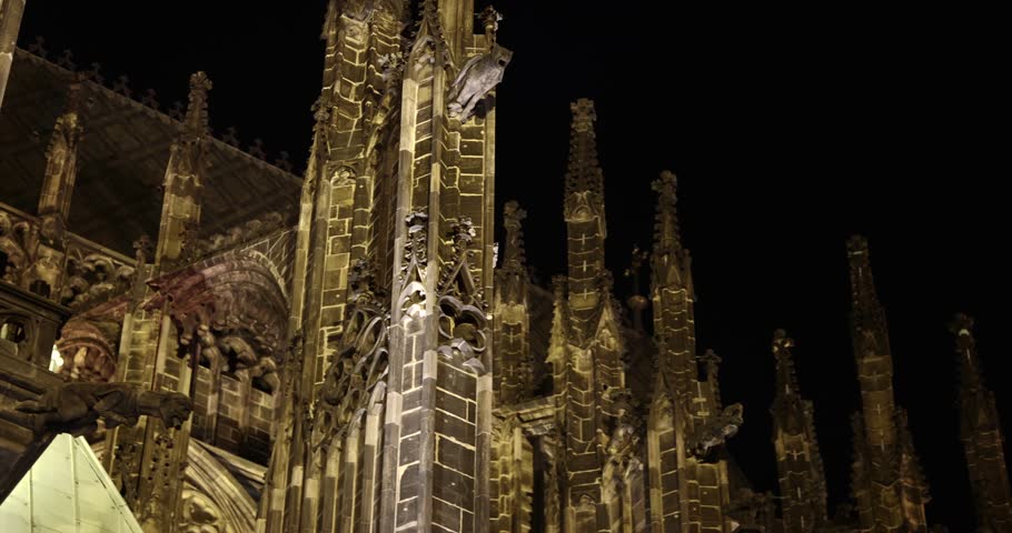 Prague St. Vitus Cathedral gothic church building detailed view at night illuminated in the dark, dramatic tall towers with gargoyles and sculptures