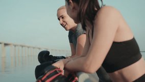 Two sportive women share a fulfilling moment outdoors after a boxing training session, showcasing friendship and fitness. - Powered by Shutterstock - Get 15% off with code: PIKWIZARD15