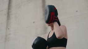 Two athletic women engage in an outdoor boxing training session, practicing punches with a focused personal trainer using pads. - Powered by Shutterstock - Get 15% off with code: PIKWIZARD15