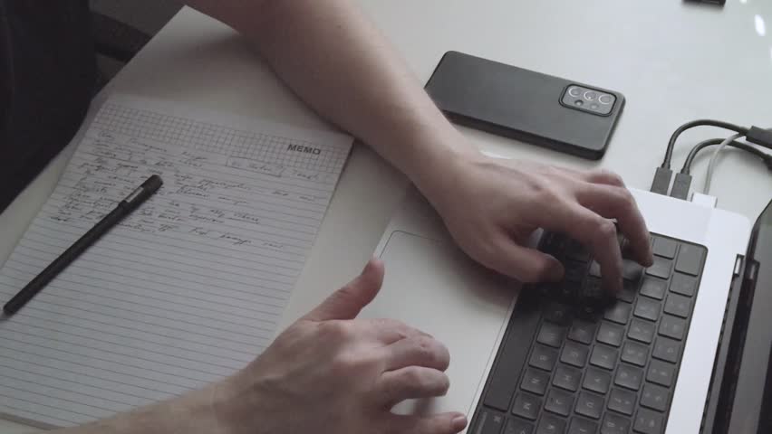 Man Takes Notes While Working on Laptop (Timelapse)