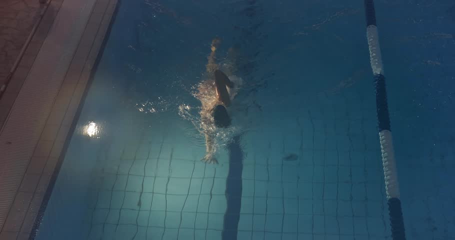 Woman swimming in an indoor swimming pool freestyle stroke