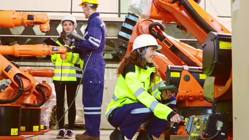Male and female robot engineering team planning electricians brainstorming presenting knowledge checking electrical system blueprints new welding robots testing automatic electronics in the warehouse. - Powered by Shutterstock - Get 15% off with code: PIKWIZARD15