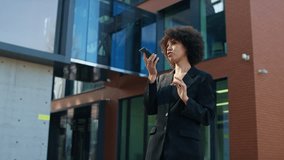 Businesswoman recording voice message outside office - Powered by Shutterstock - Get 15% off with code: PIKWIZARD15