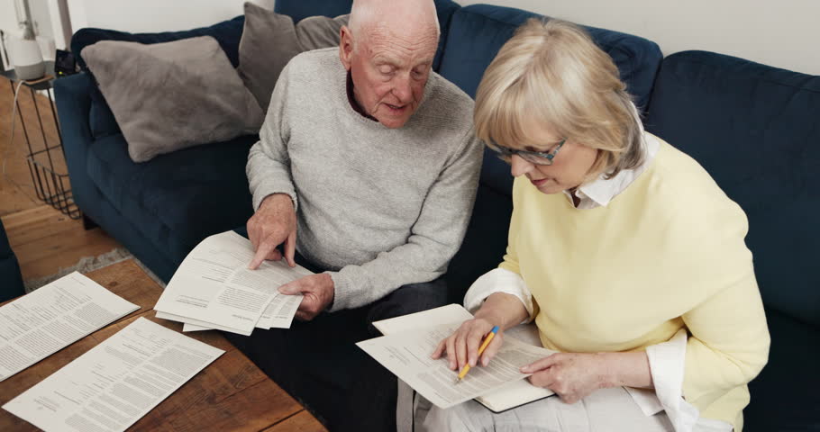 Old couple, home and reading documents, debt and contract for life insurance policy from above. Senior man, woman and discussion of retirement savings, pension report and planning financial mortgage