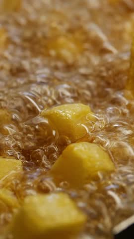 Frying golden potatoes in hot oil at a bustling kitchen