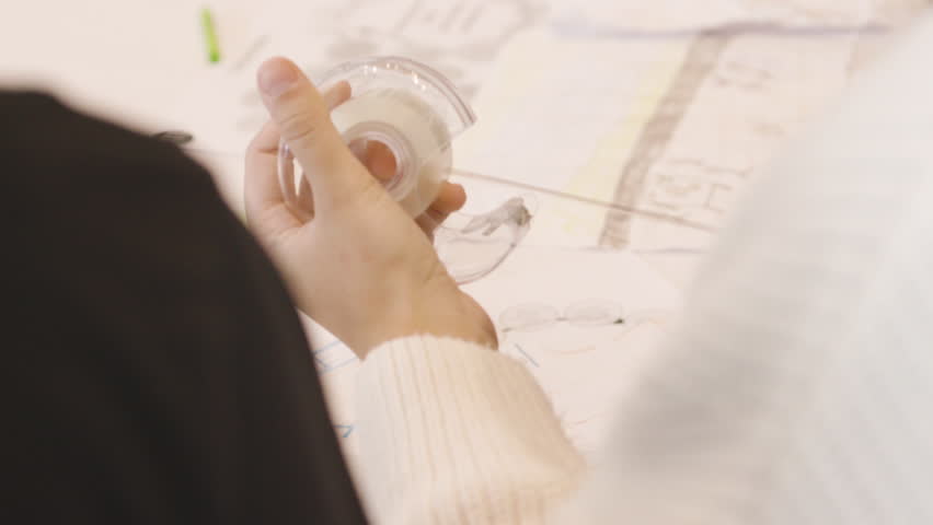scotch tape female student doing homework and crafts with paper