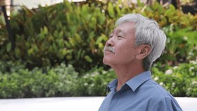Relaxed happy carefree old retired senior Asian man taking a deep breath of clean unpolluted air in city park, good summer, summer wellness, sunlight exposure for vitamin D synthesis concept image - Powered by Shutterstock - Get 15% off with code: PIKWIZARD15