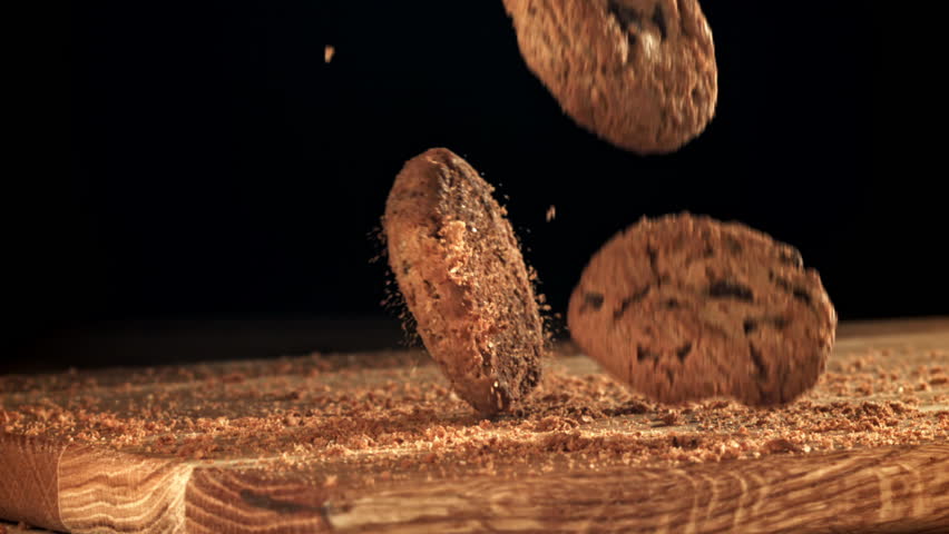 Oatmeal cookies fall on a wooden board. Filmed on a high-speed camera at 1000 fps. High quality FullHD footage