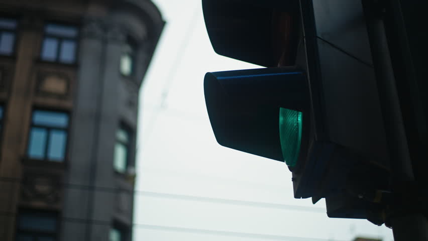 The Green Traffic Light Signal in a Bustling Urban Setting Facilitating Safe Vehicle and Pedestrian Mobility