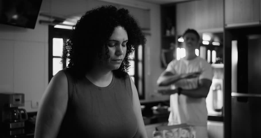 Husband and wife of African descent in kitchen, marital conflict, wife overwhelmed, hand on forehead, husband gesturing in frustration, relationship struggles, emotional tension, communication issues
