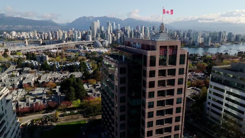 South Granville, Vancouver, Canada - A Proud Canadian Flag Waves Above the City as Downtown Vancouver and Mountain Views Stretch Beyond - Wide Shot