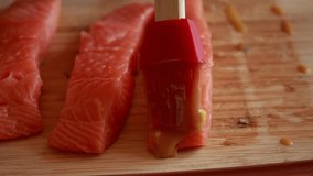 Close-up video of brushing raw salmon fillets with mustard sauce - Powered by Shutterstock - Get 15% off with code: PIKWIZARD15