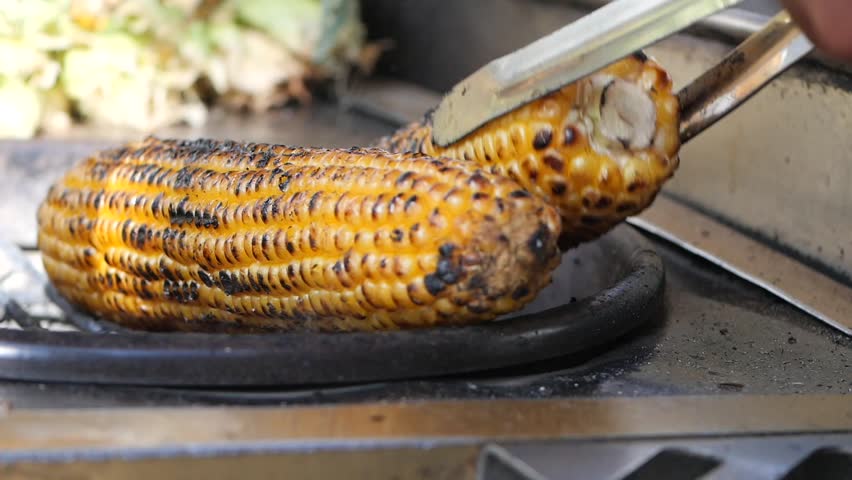 Grilling corn on the cob at a vibrant street food market