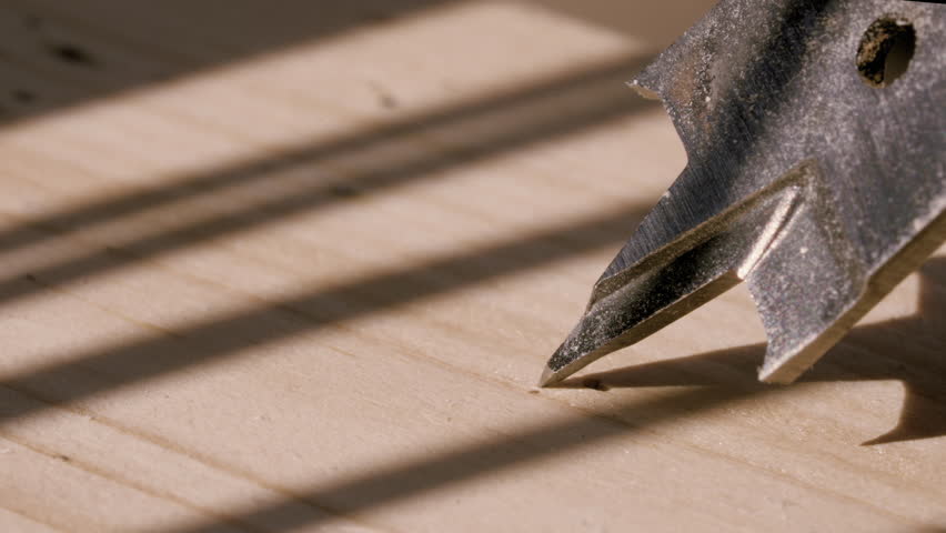 A powerful drill as it cuts into wood, sending fine particles and fibers flying. The motion blur and dust create a raw, kinetic energy that highlights the intensity of craftsmanship.