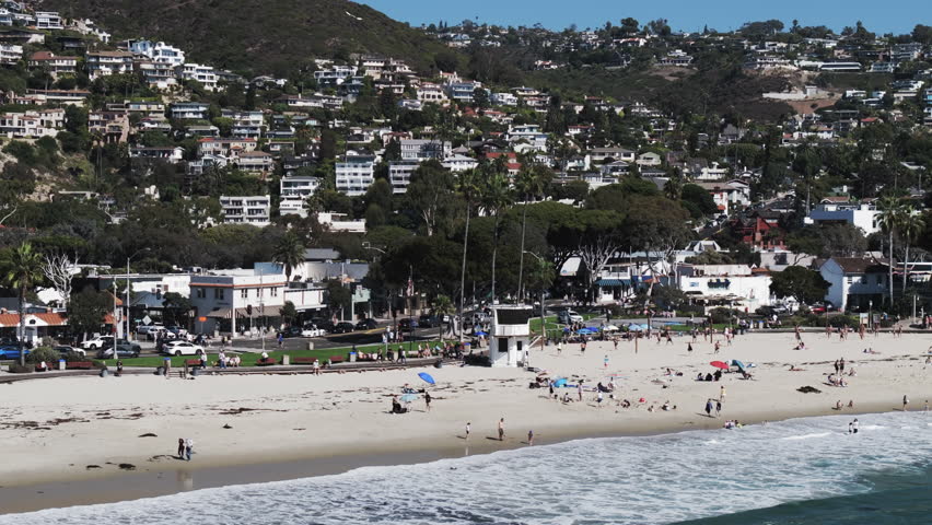 Aerial: Drone Panning Shot Of Male And Female Tourists At Beach On Sunny Day - Laguna Beach, California